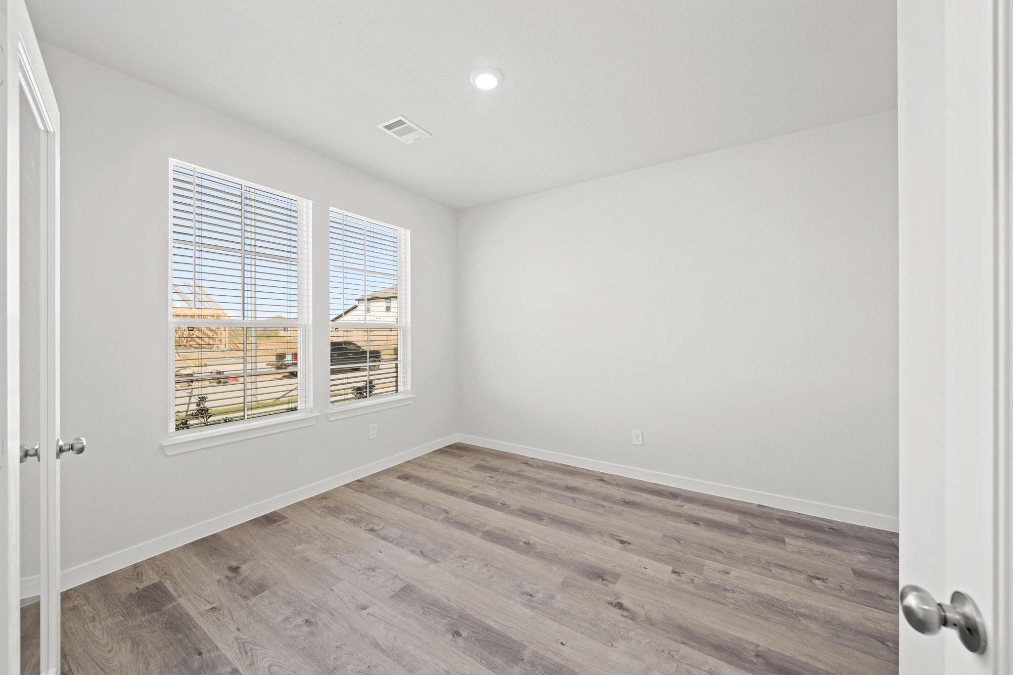 A room with a wood floor and windows.