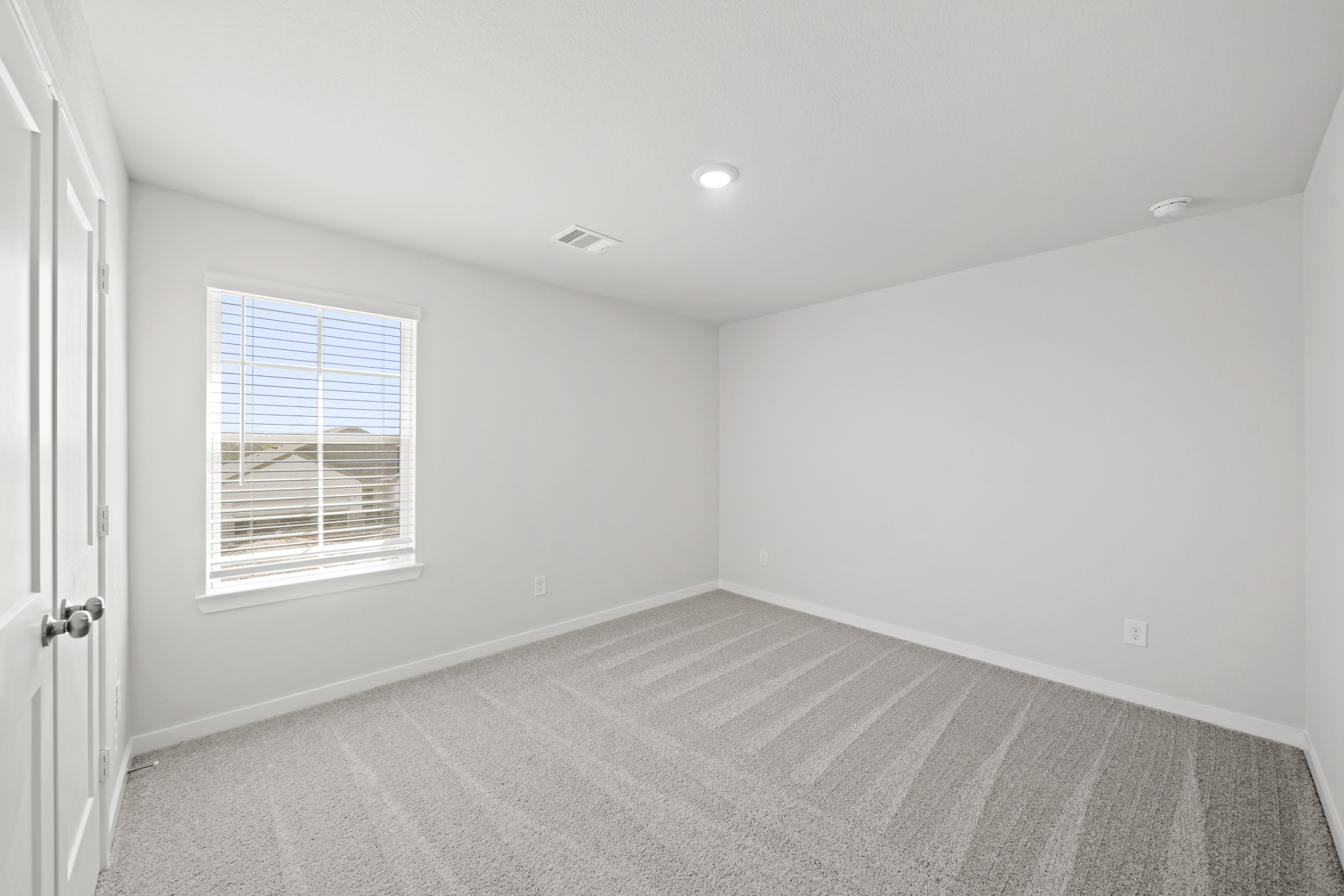 A room with a window and a rug.