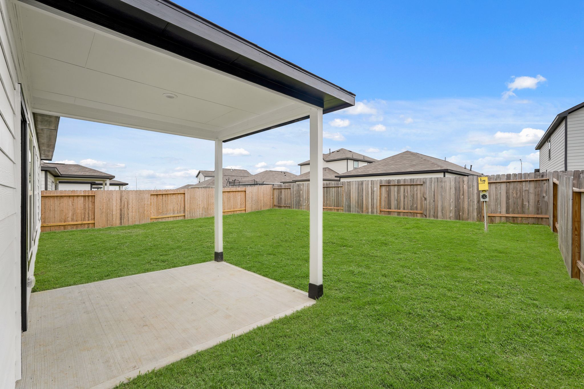 A fenced in yard with a building in the background.