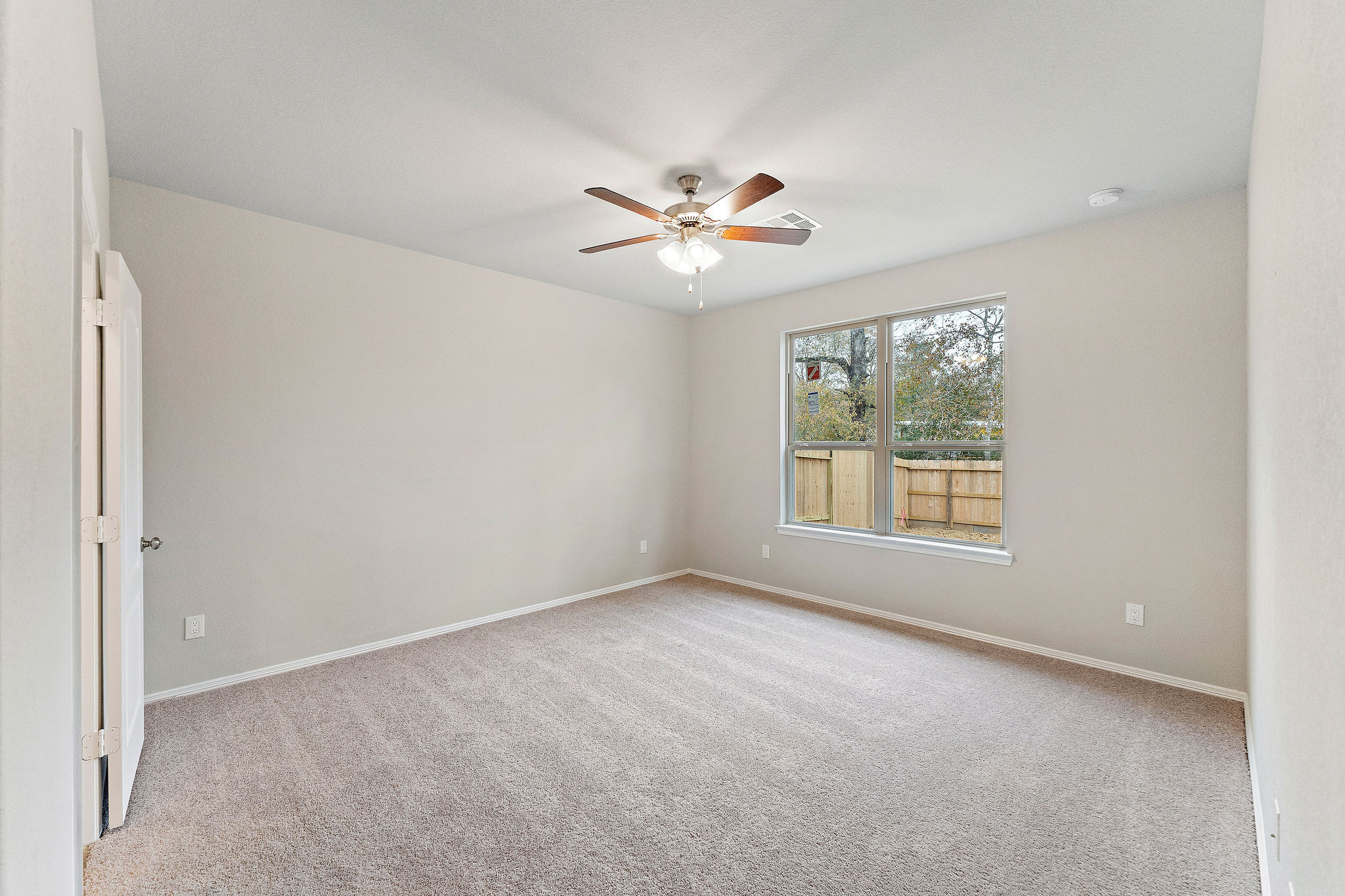 A room with a ceiling fan and a window.