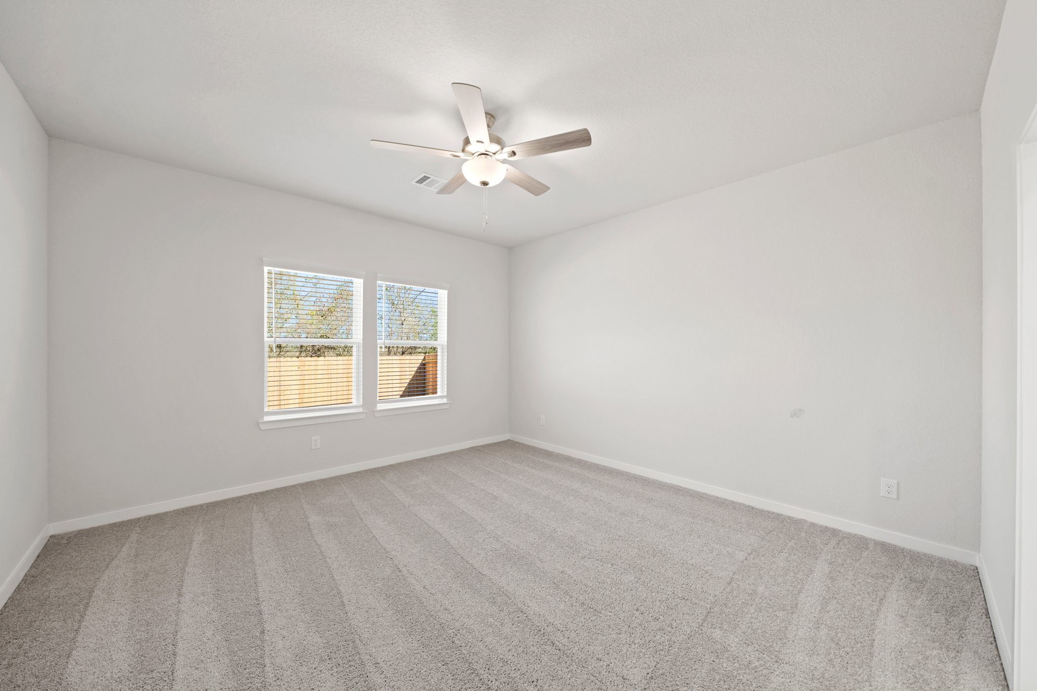 A room with a ceiling fan and a window.