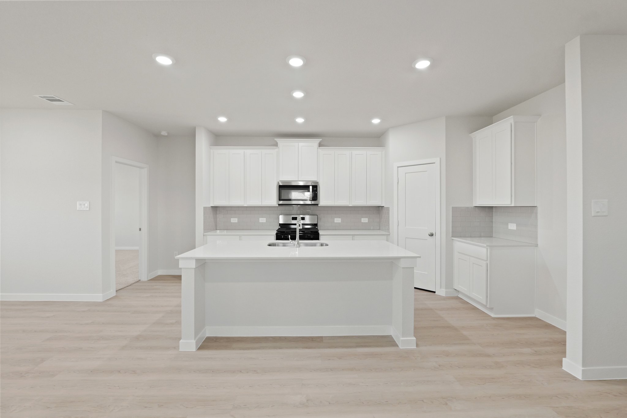 A kitchen with white cabinets.
