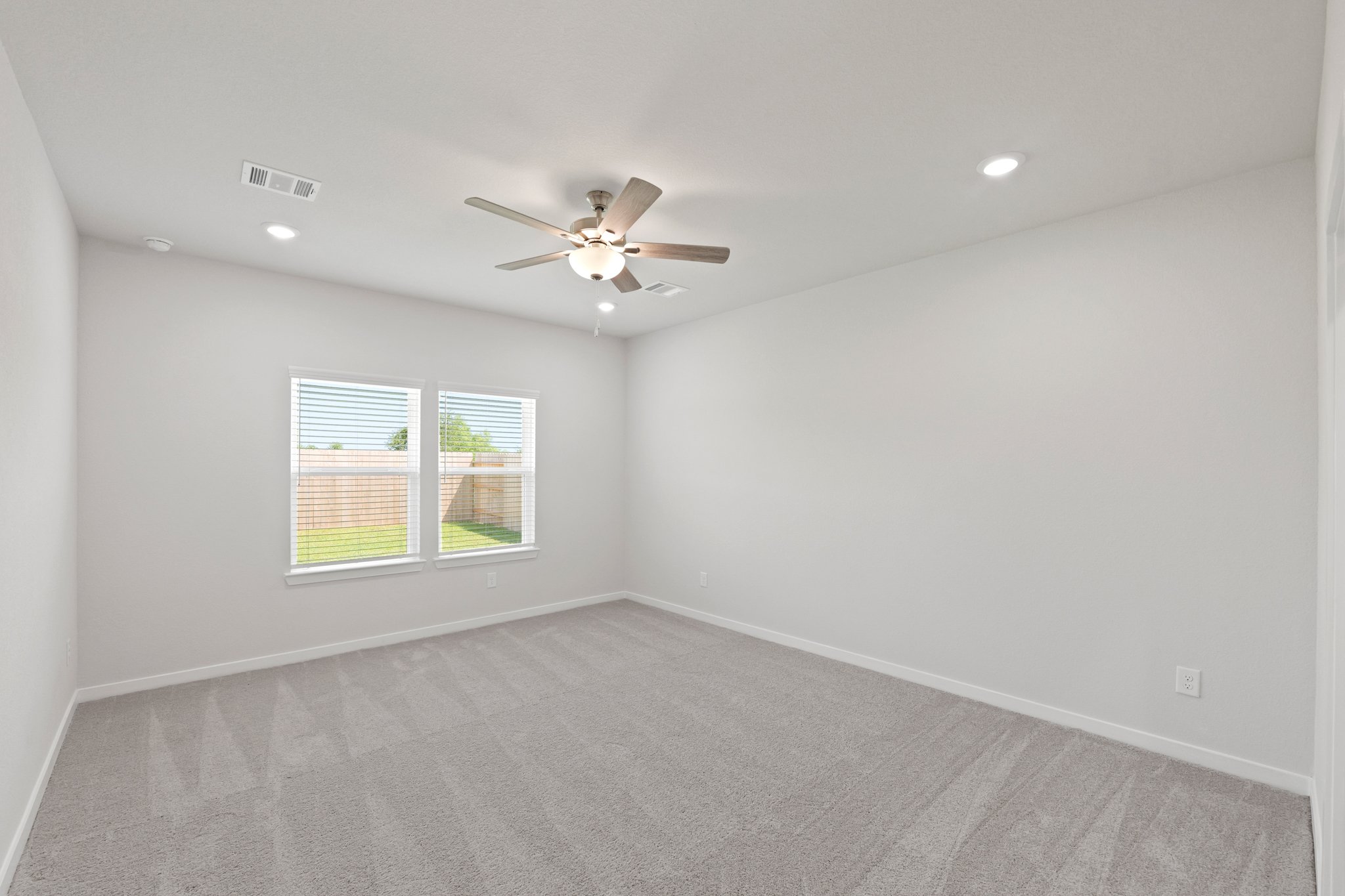 A room with a ceiling fan and a window.