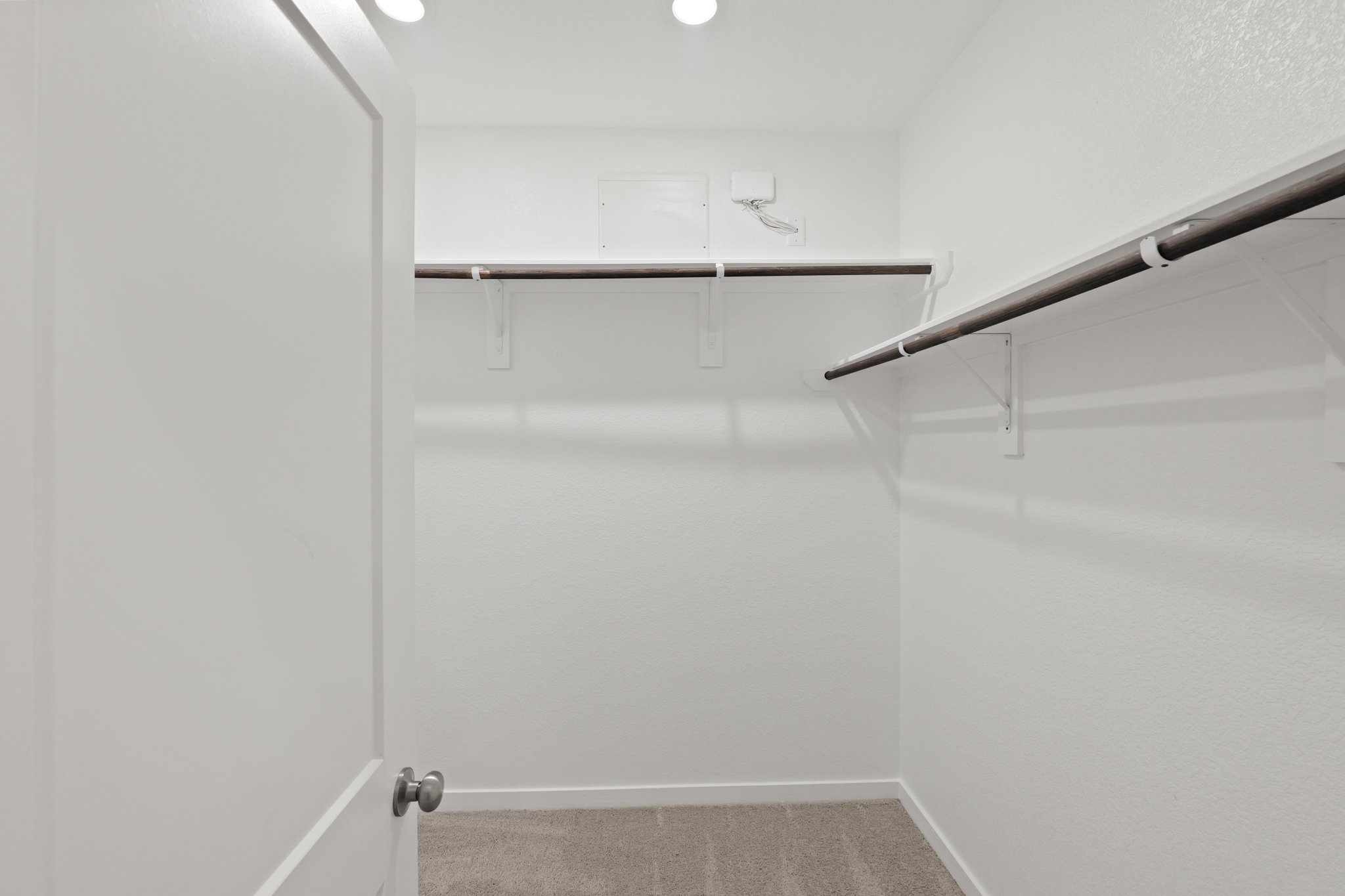 A white wall with a metal bar.