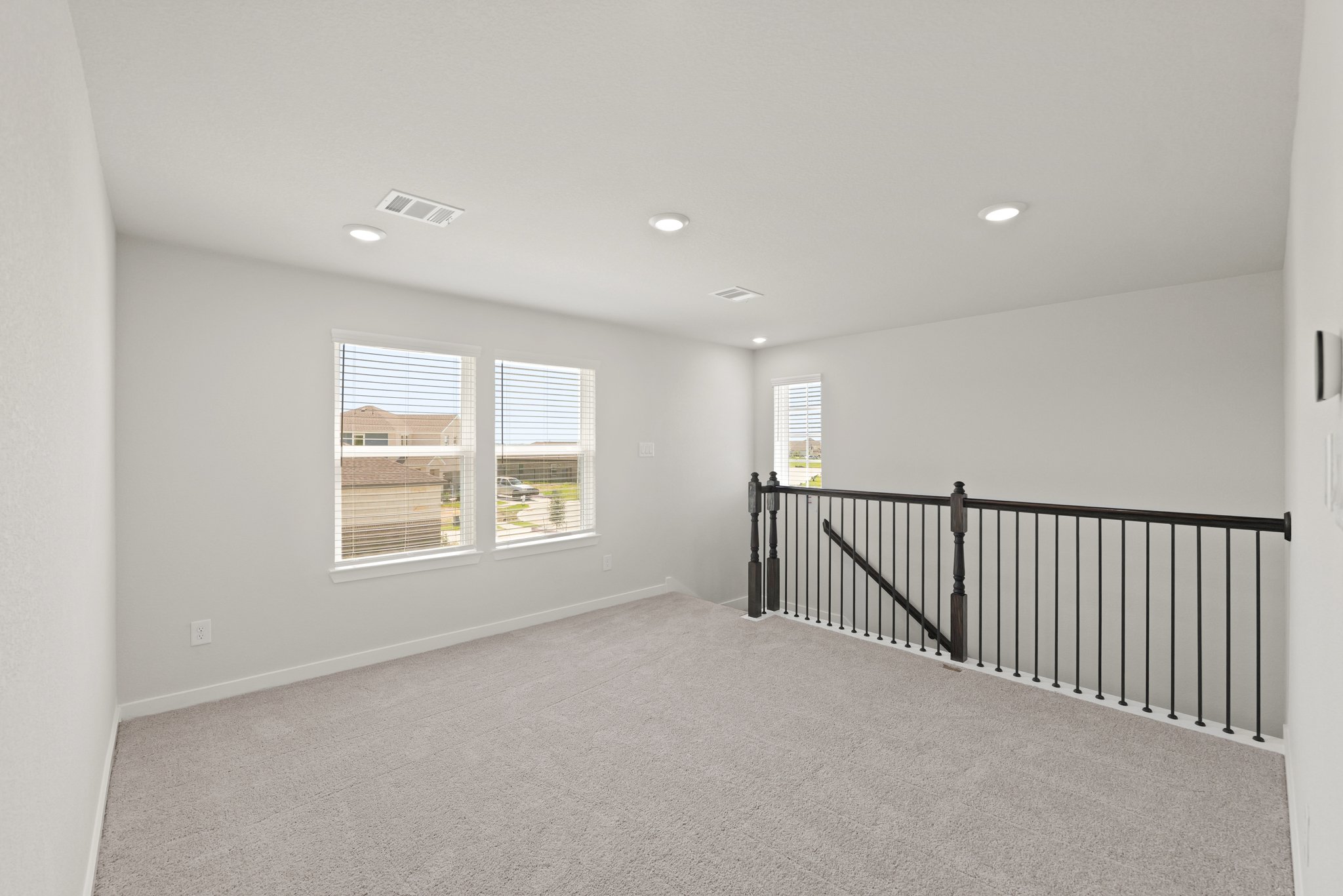 A room with a railing and windows.