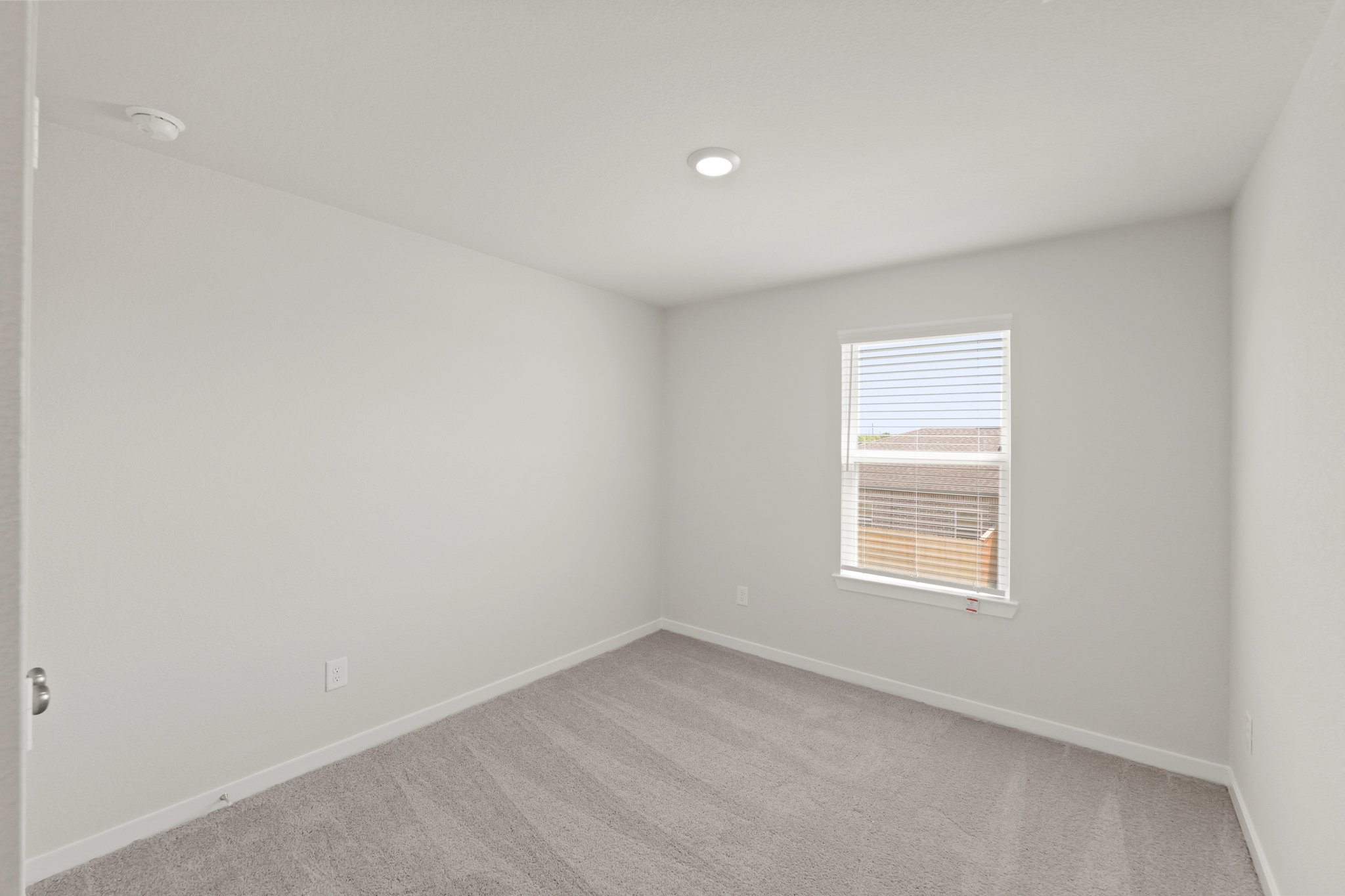 A room with a window and a carpet.