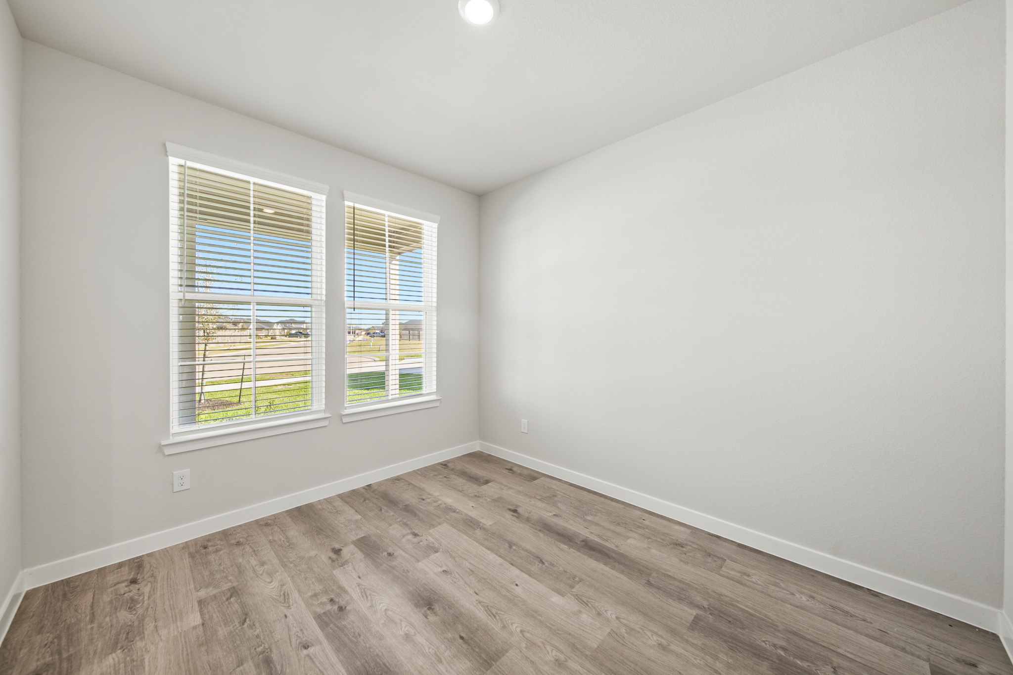 A room with a wood floor and windows.