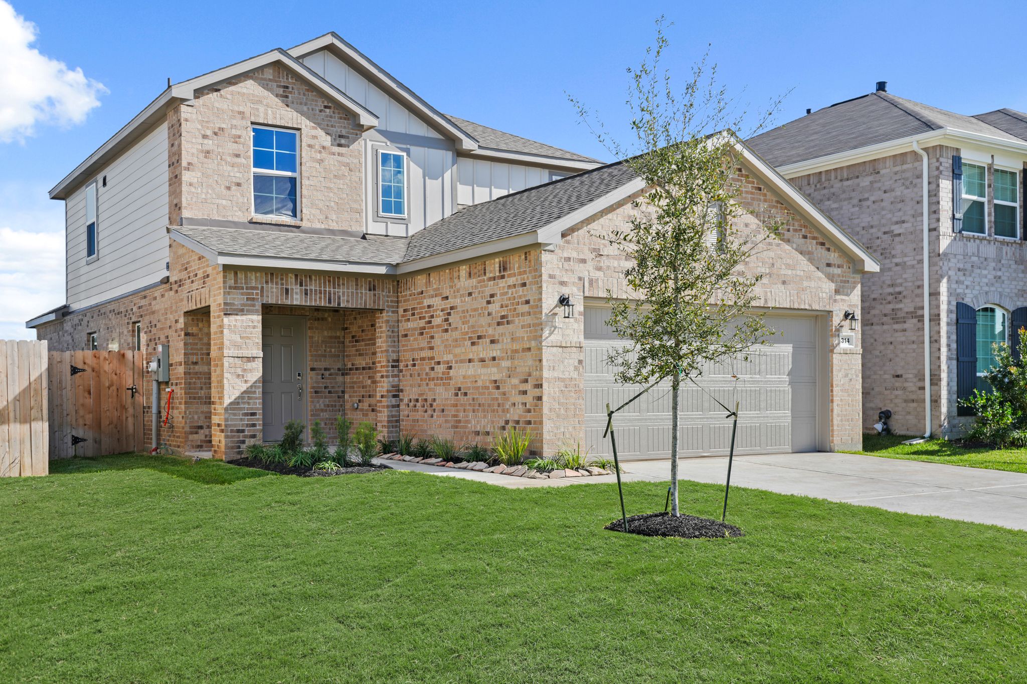 A large brick house with a tree in the front yard.