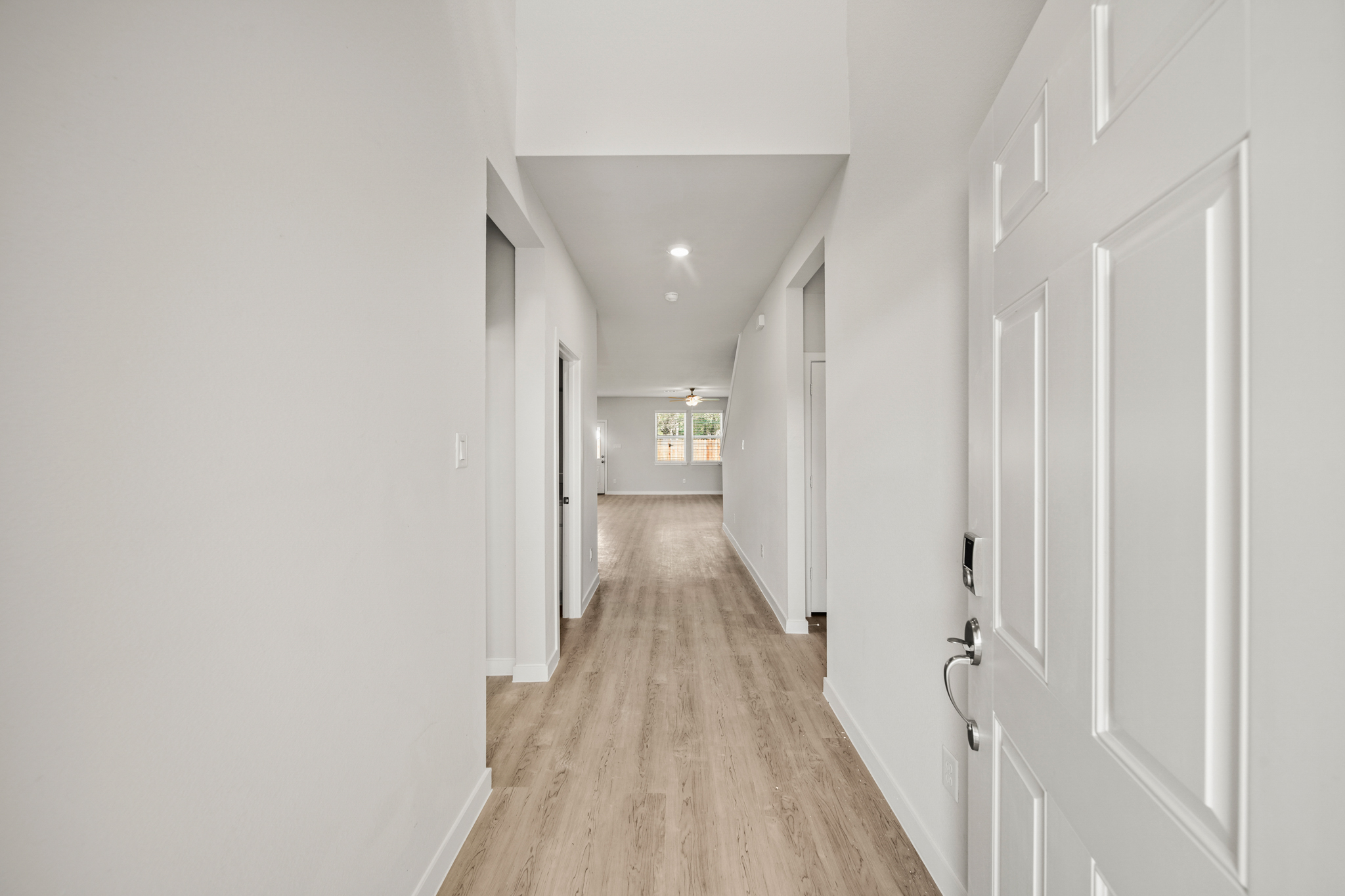 A long hallway with white doors.