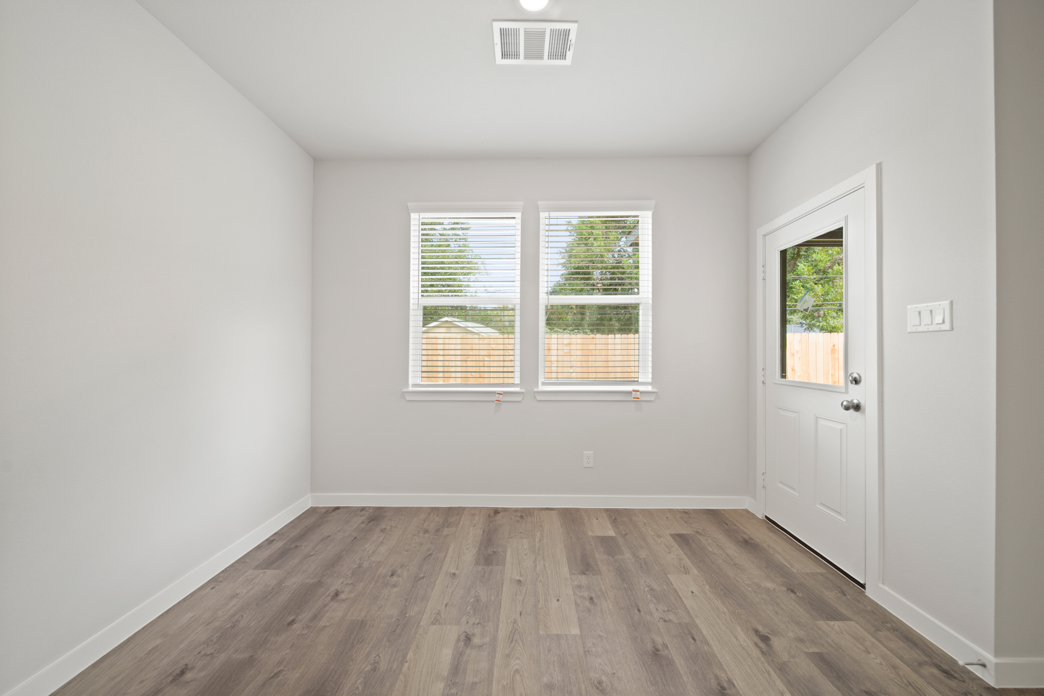 A room with a wood floor and windows.