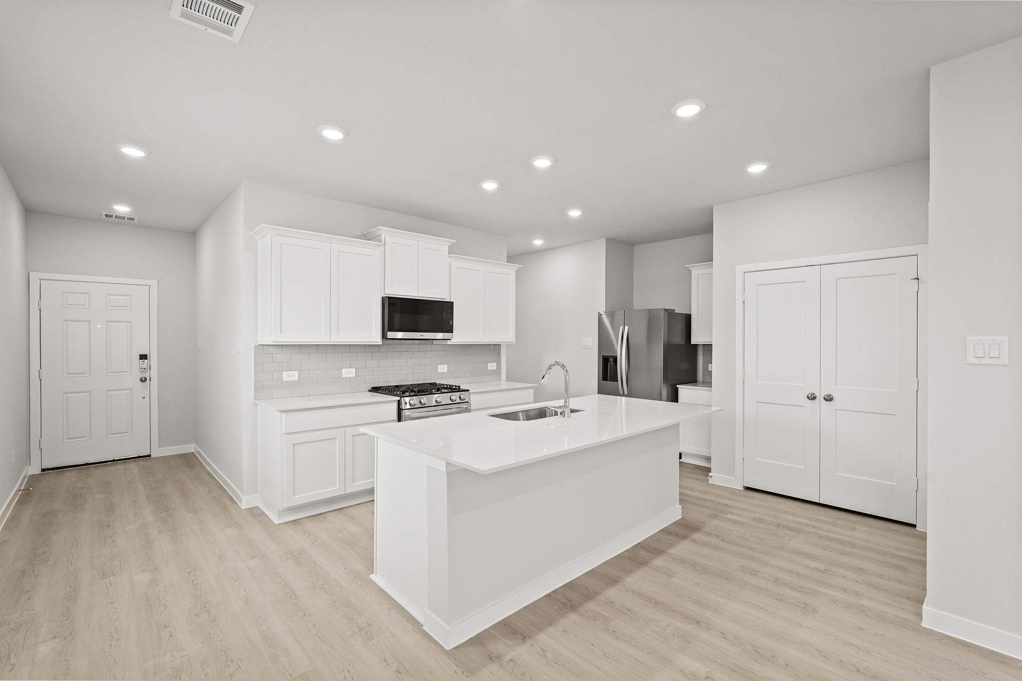 A kitchen with white cabinets.