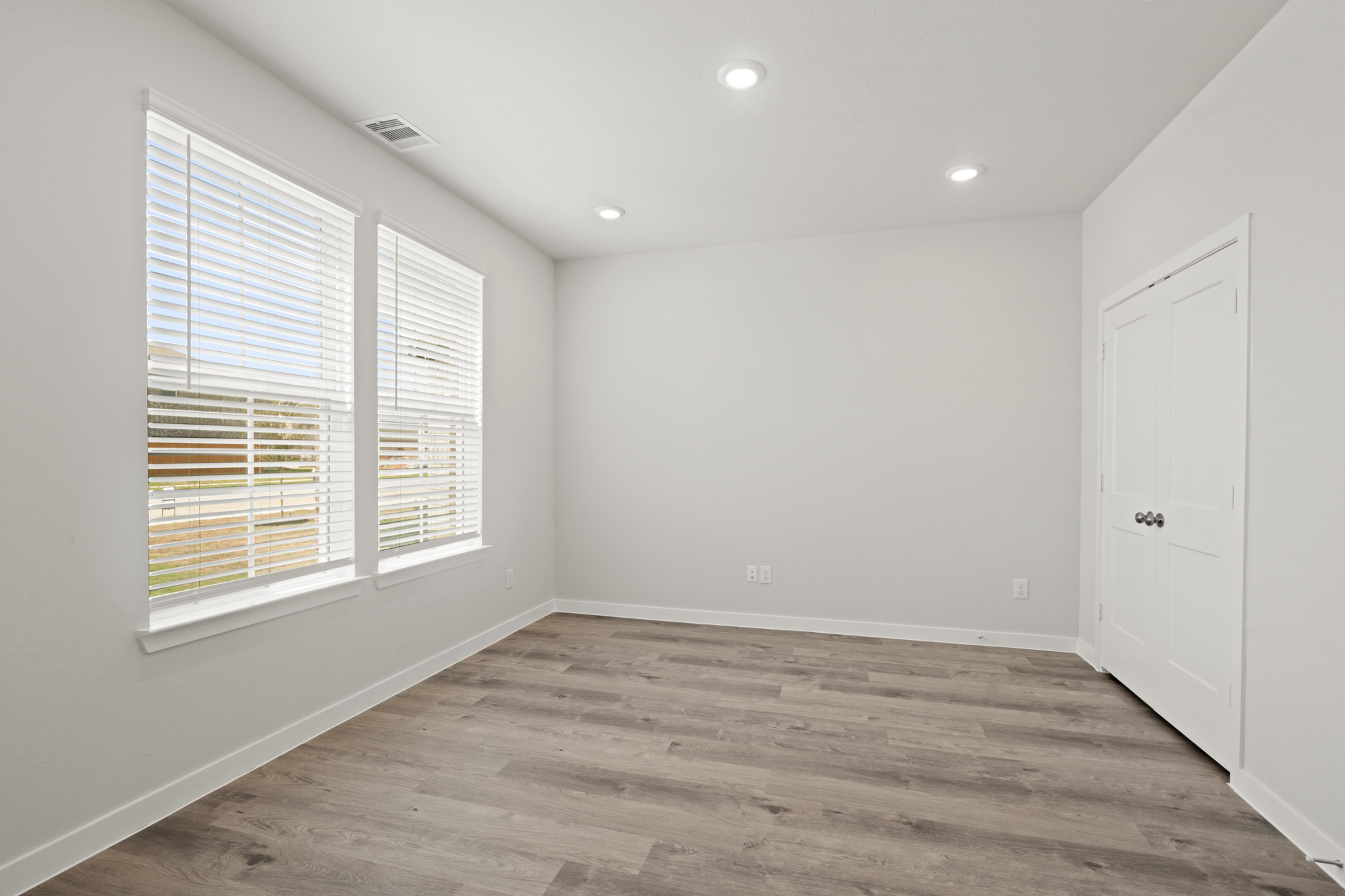 A room with a wood floor and white walls.