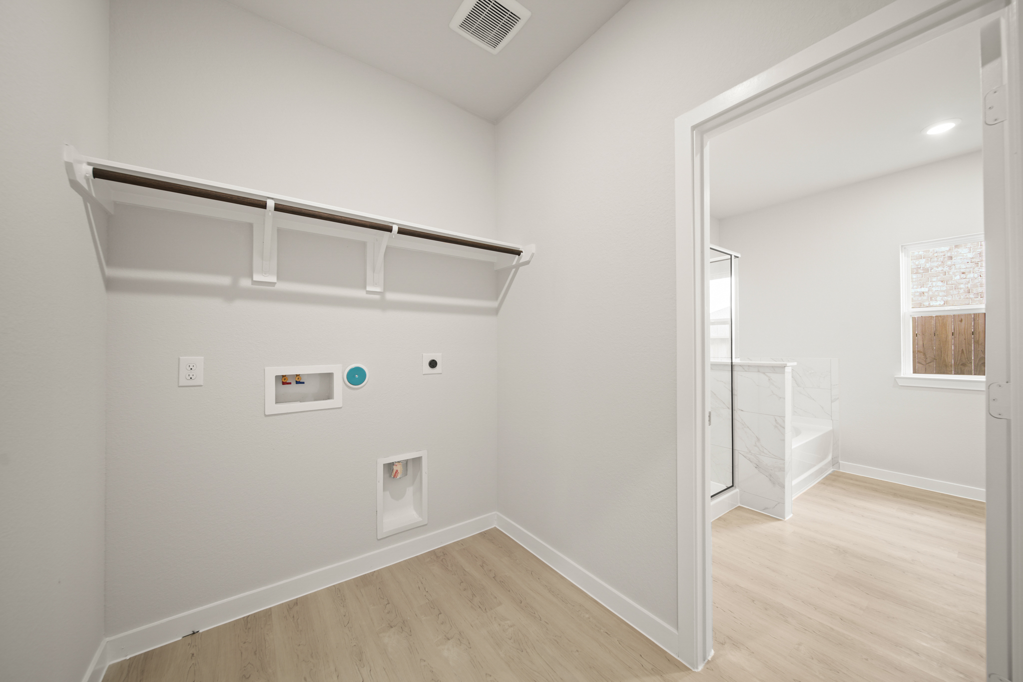 A room with a mirror and a wood floor.