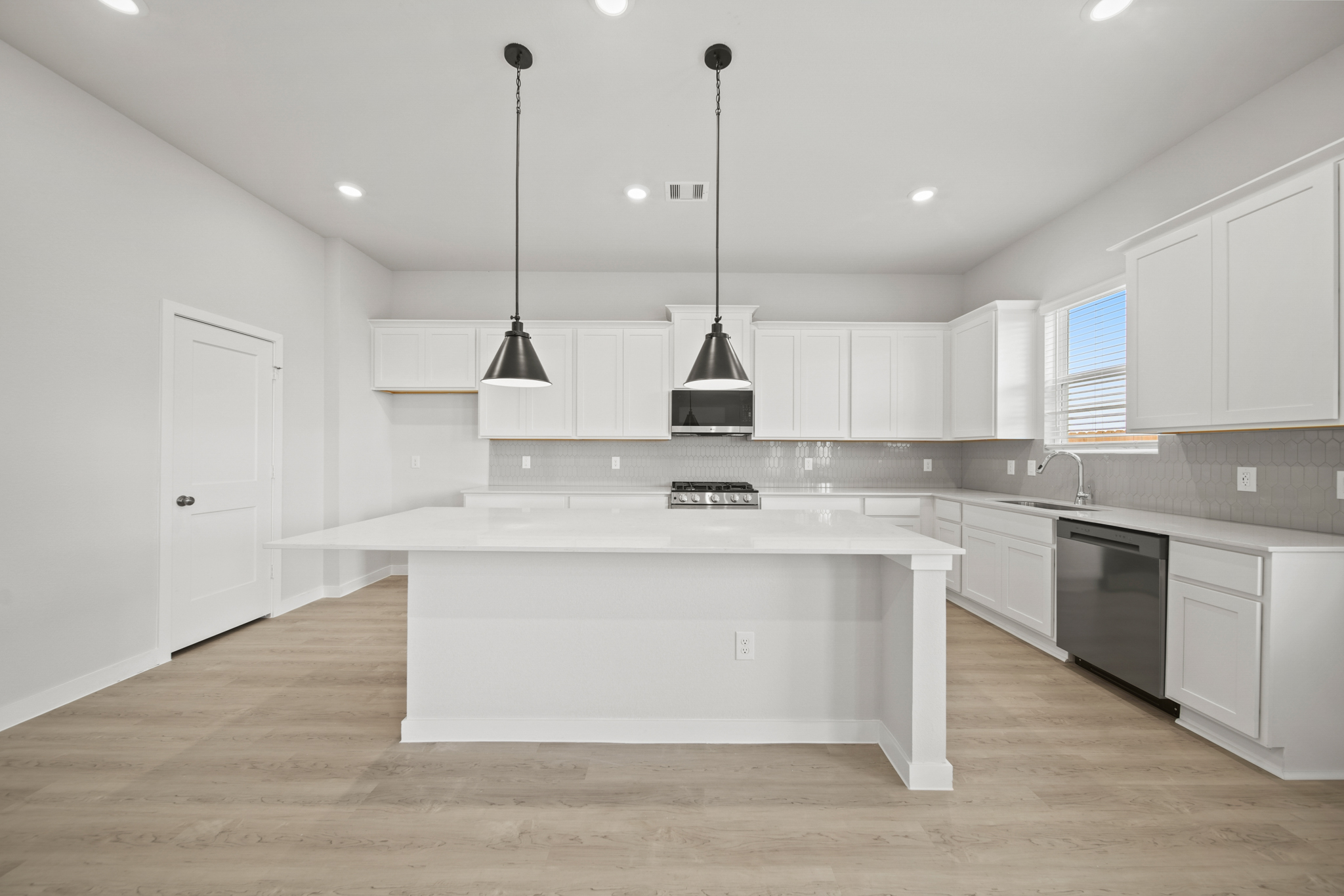 A kitchen with white cabinets.