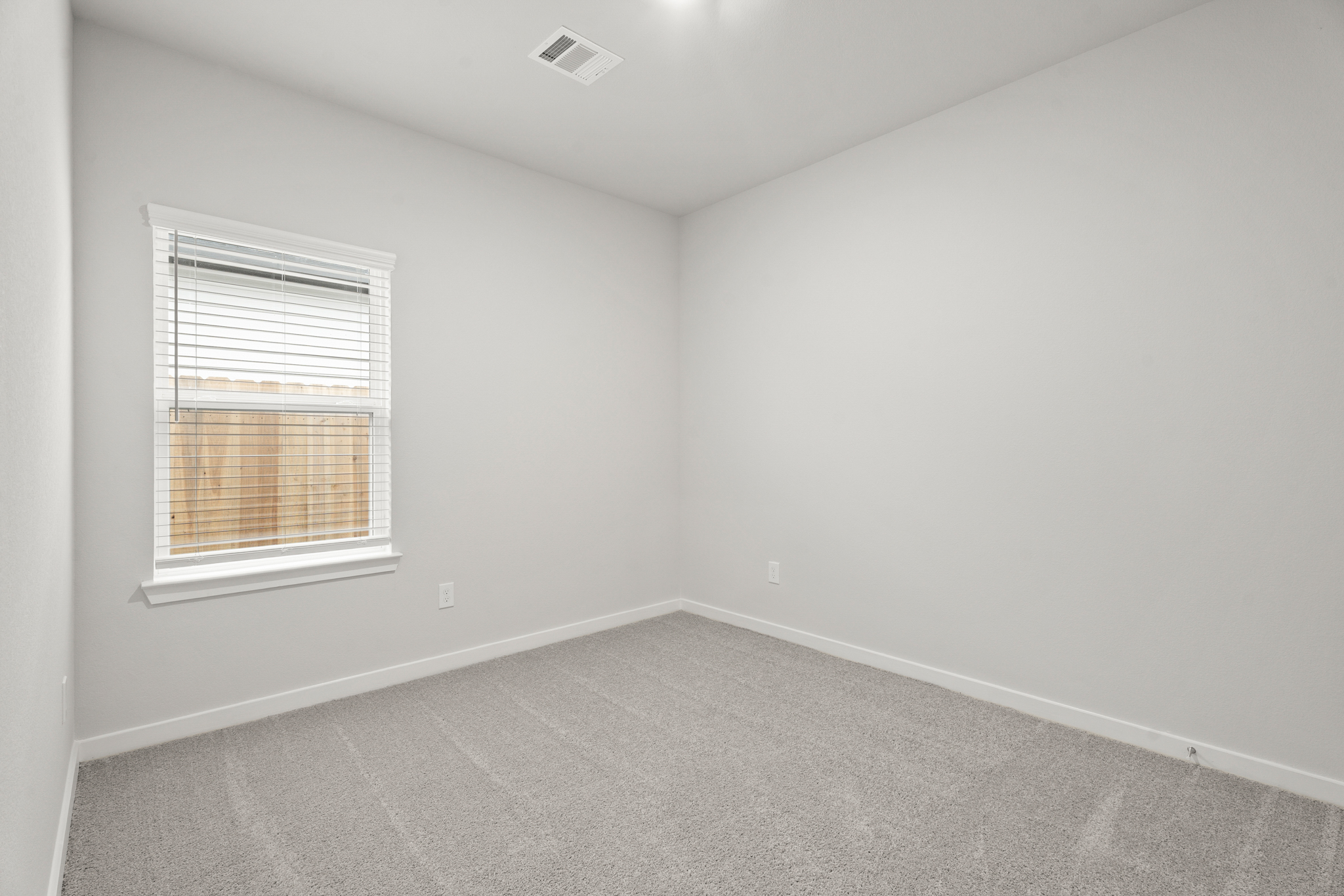 A room with a window and a carpet.