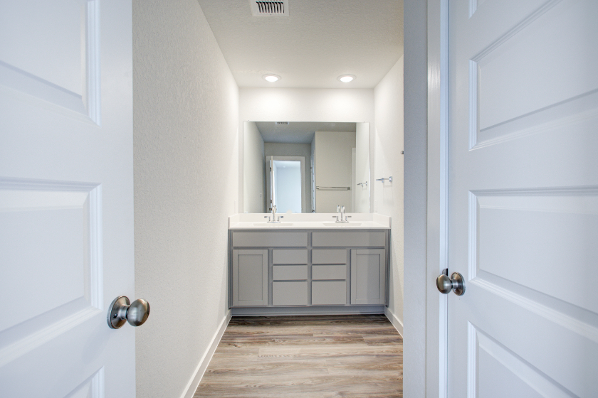 A bathroom with white cabinets.