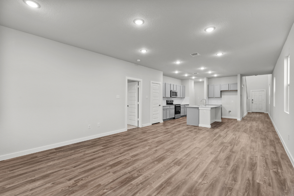 A room with white walls and wood floors.