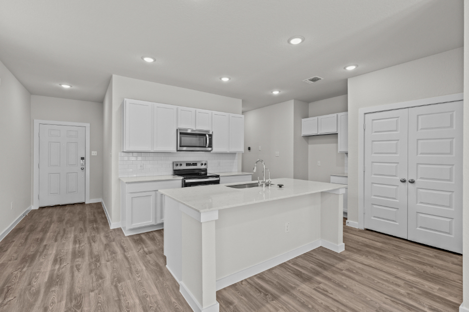 A kitchen with white cabinets.