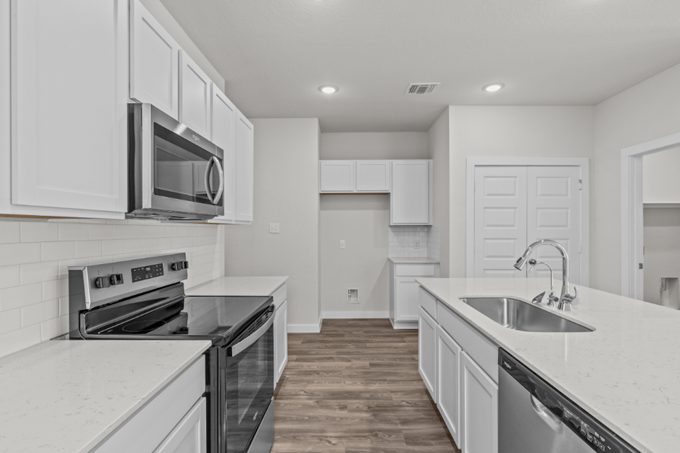 A kitchen with white cabinets.