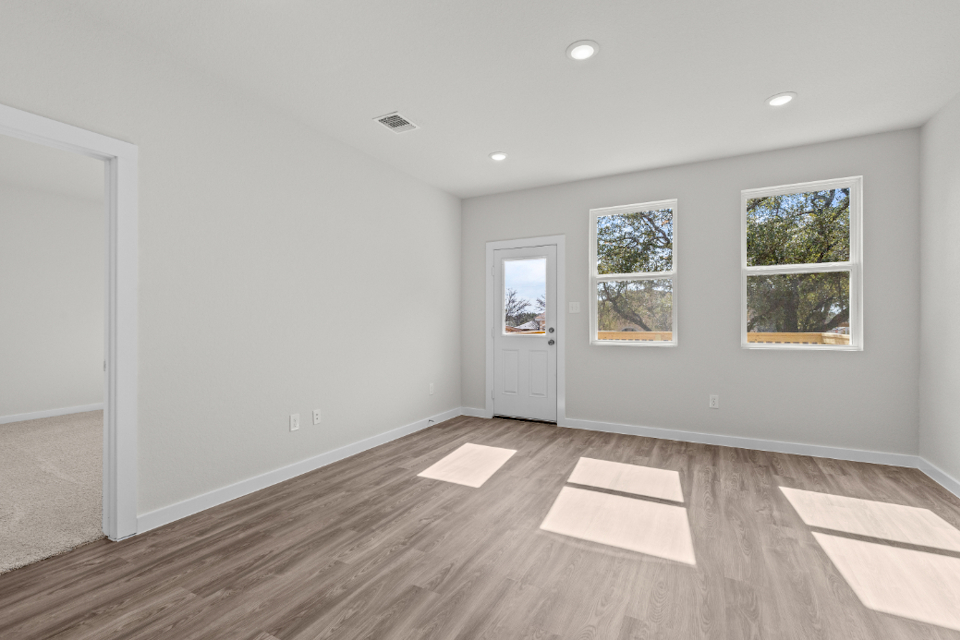 A room with a wood floor and windows.