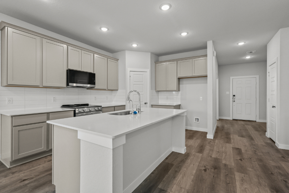 A kitchen with white cabinets.