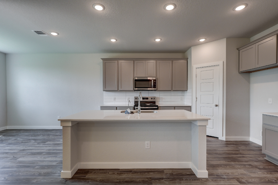 A kitchen with white cabinets.