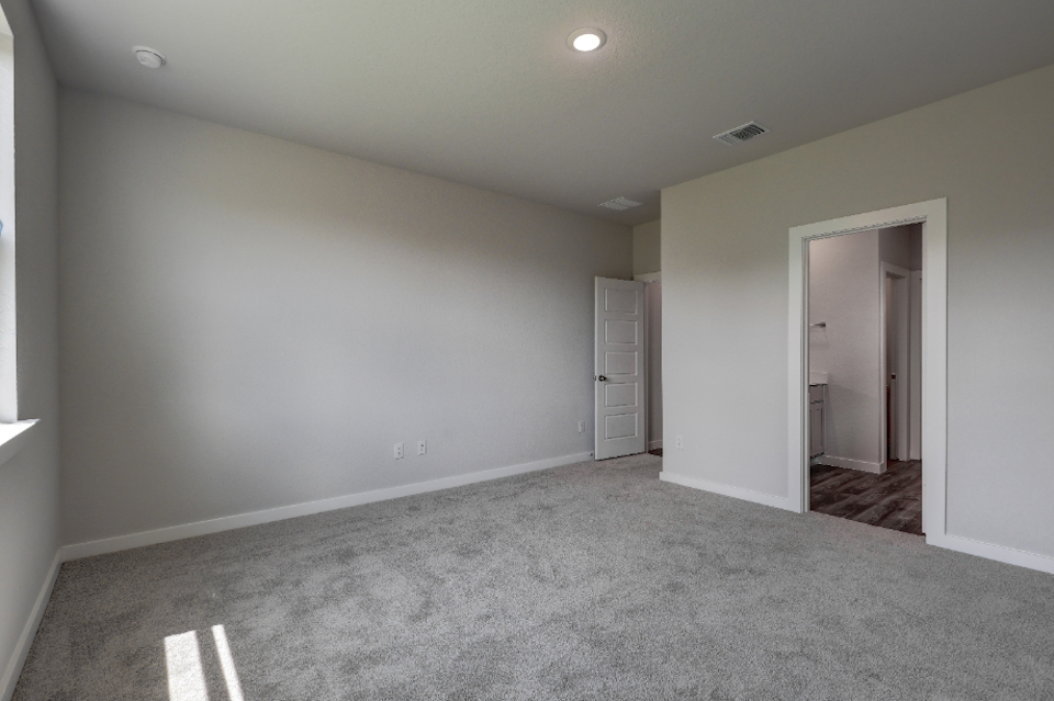 A room with a carpet and a door.