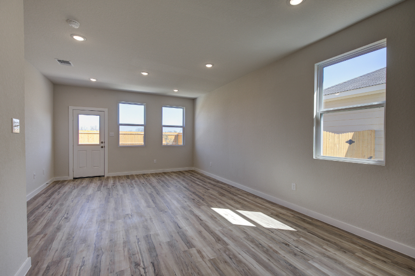 A room with a wood floor and windows.