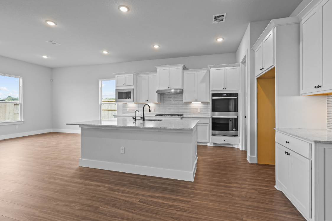 A kitchen with white cabinets.