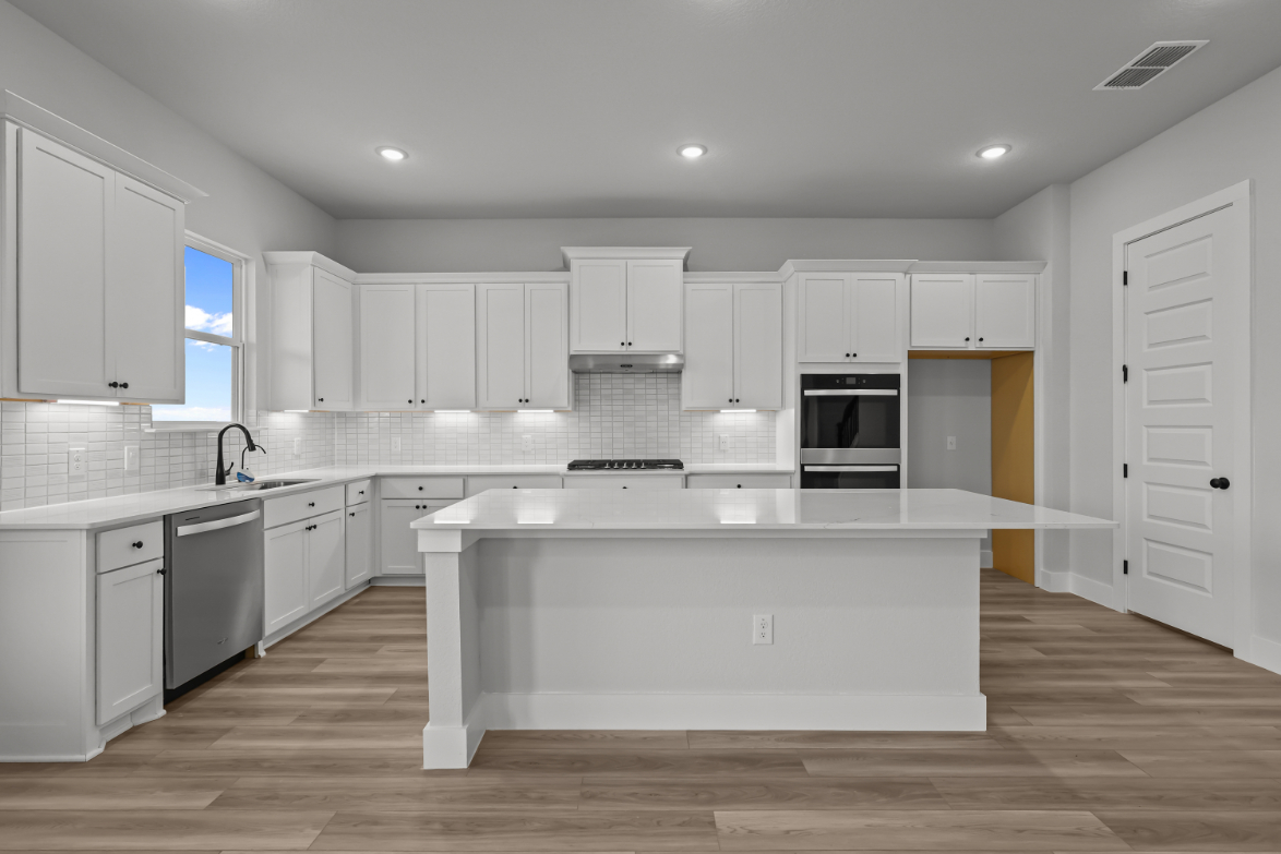 A kitchen with white cabinets.