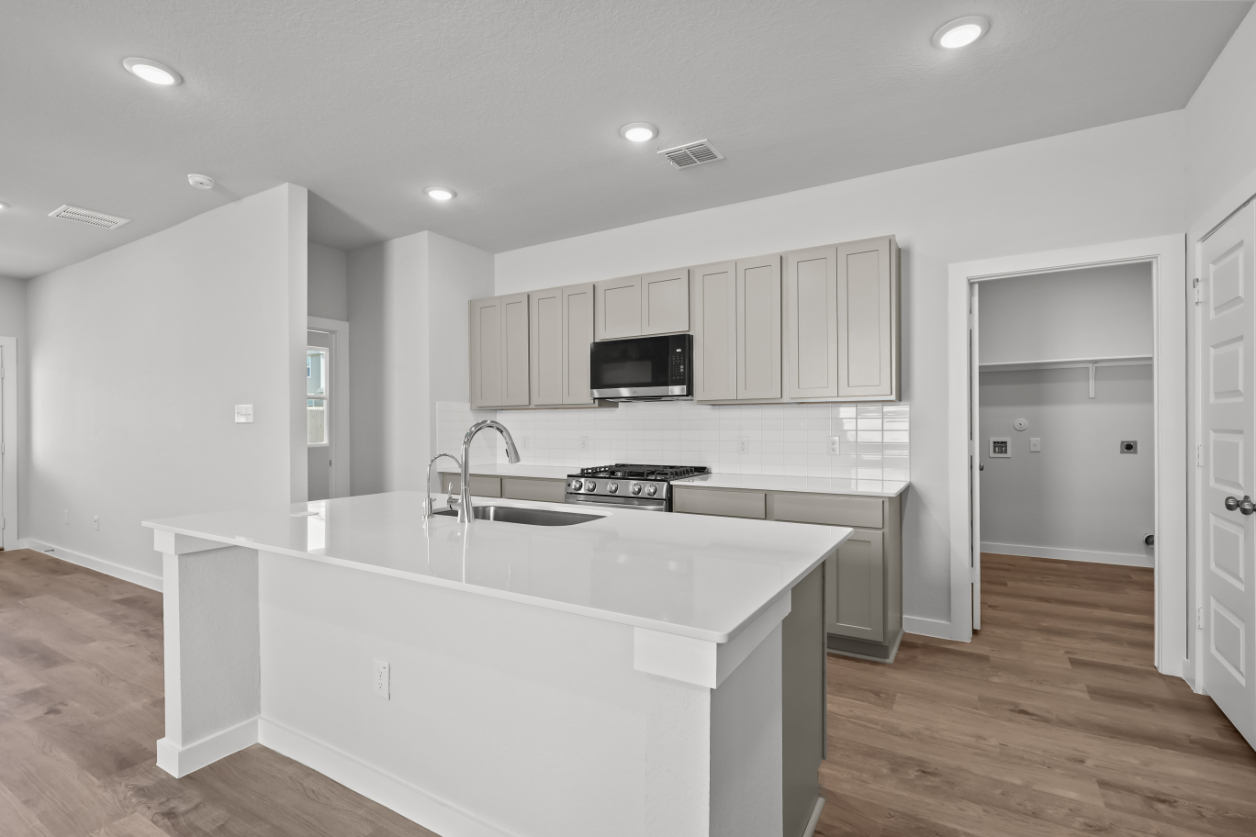 A kitchen with white cabinets.