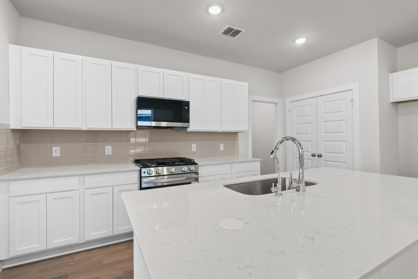 A kitchen with white cabinets.