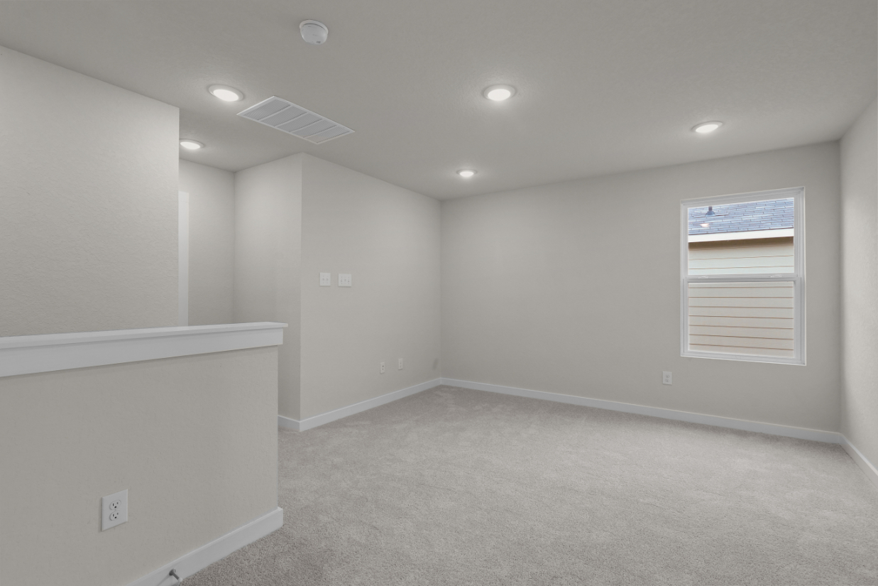 A room with a carpet and a window.