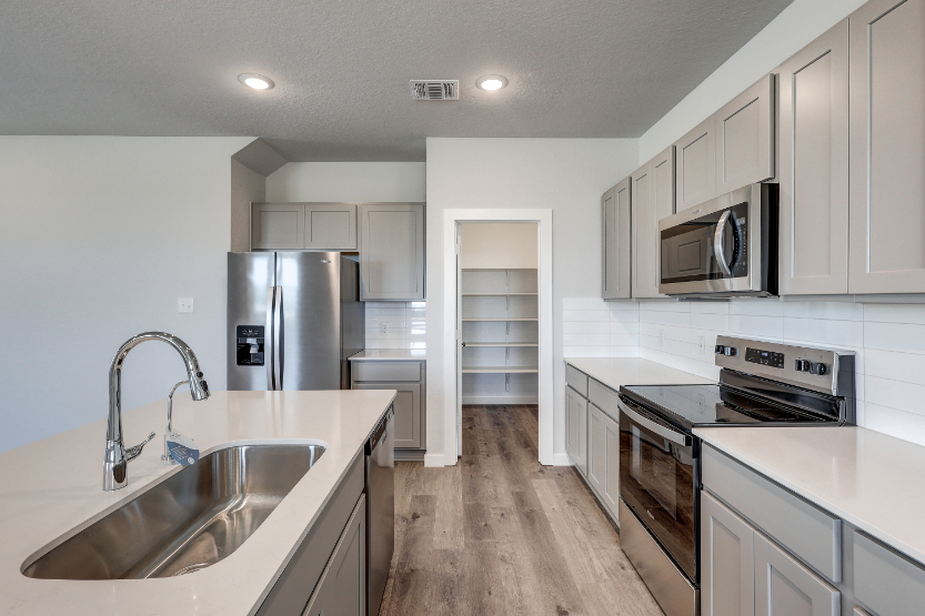 A kitchen with white cabinets.