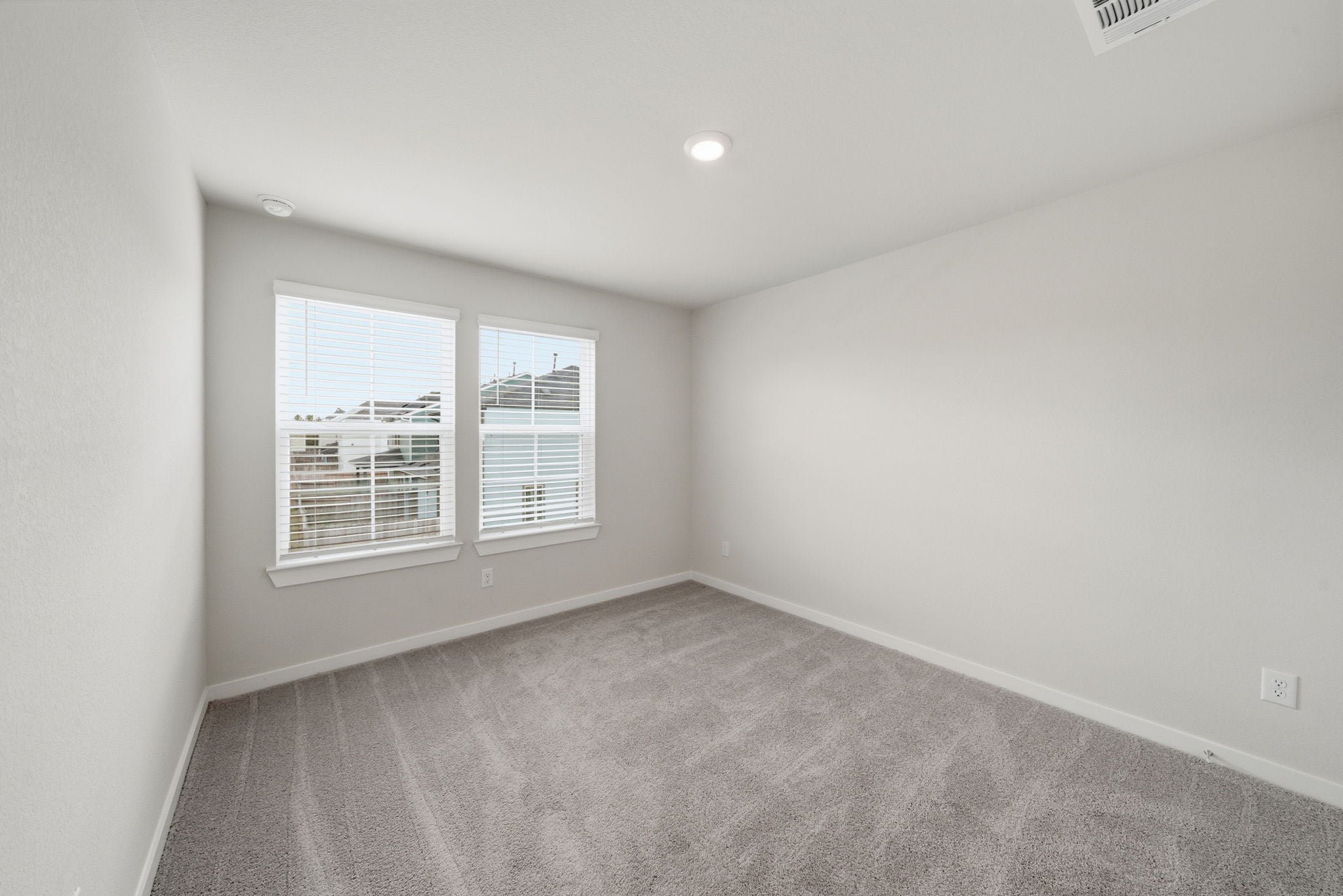 A room with a window and a carpet.