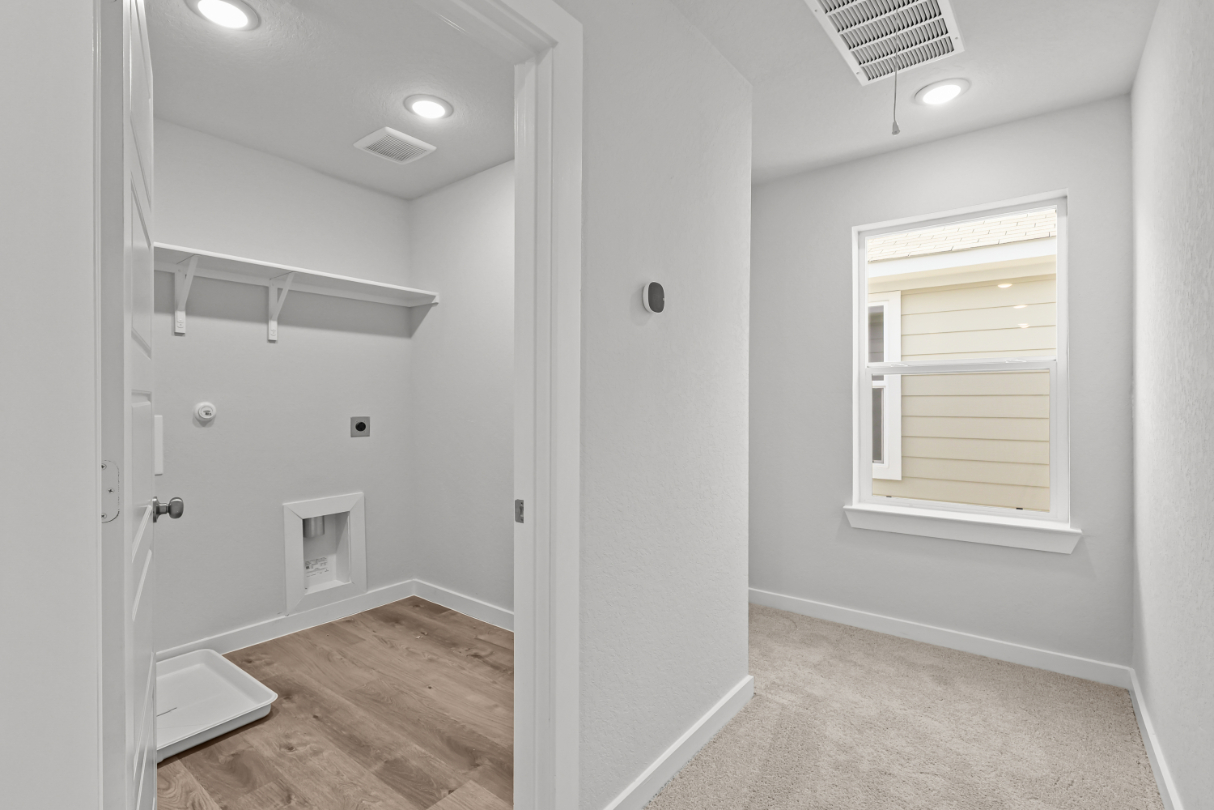 A room with a window and a white wall.