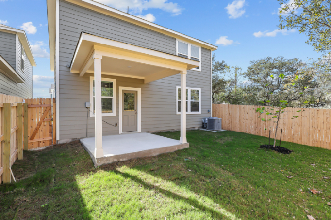 A house with a fence and a yard with a wood fence.