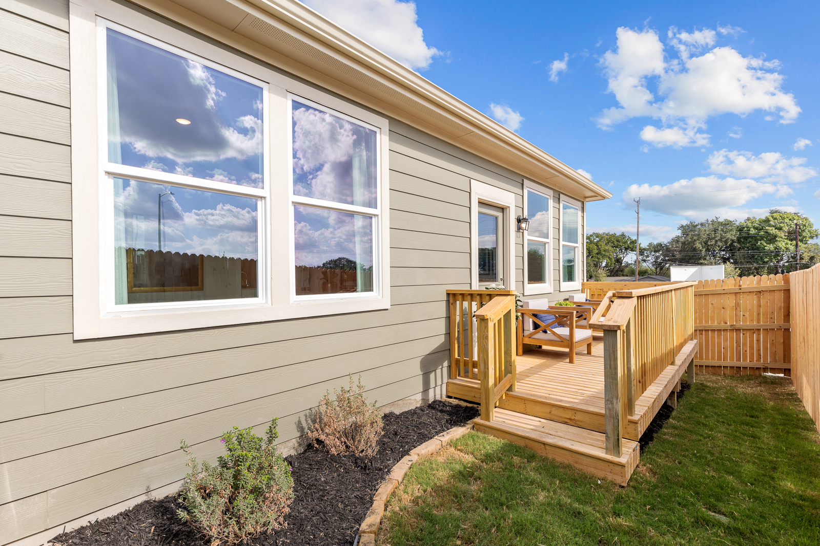 A house with a deck and a fence.