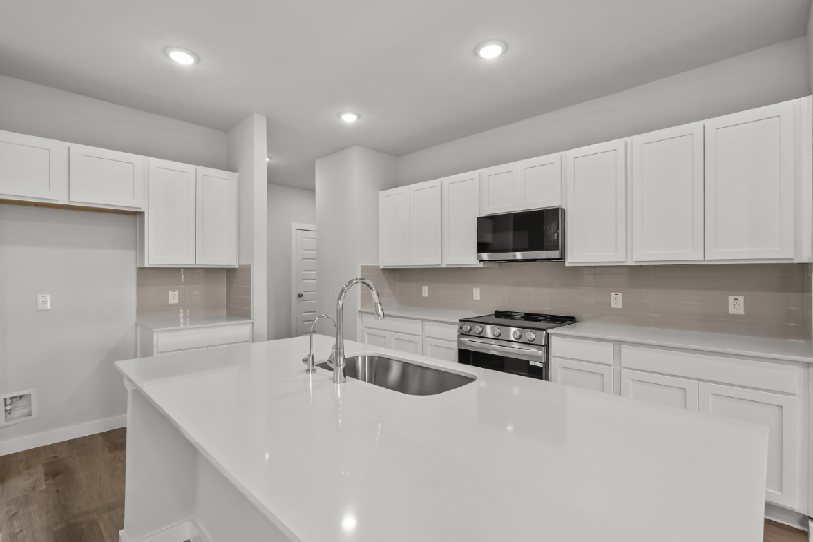 A kitchen with white cabinets.