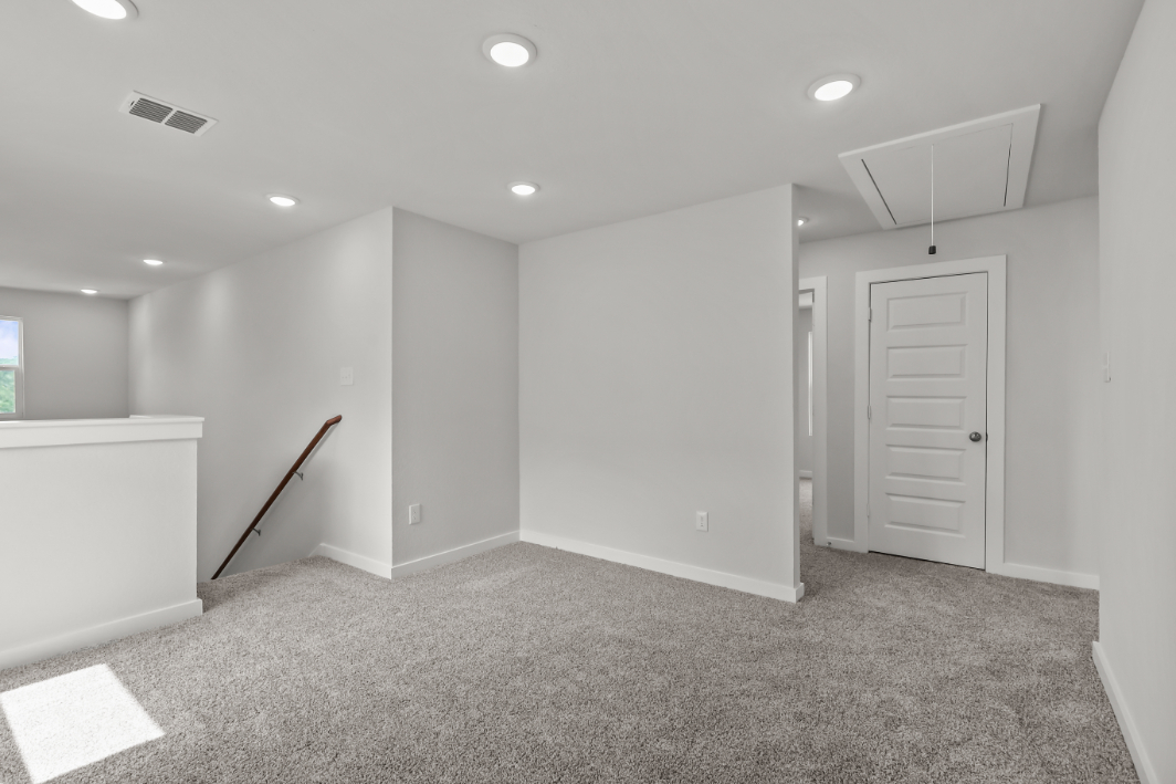 A room with white walls and a broom in it.