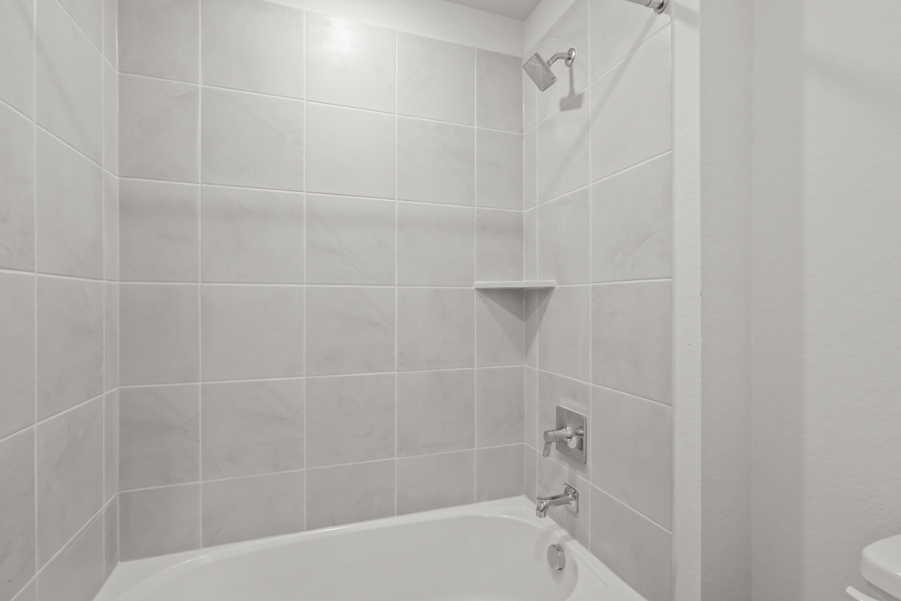 A bathroom with a bathtub and toilet.