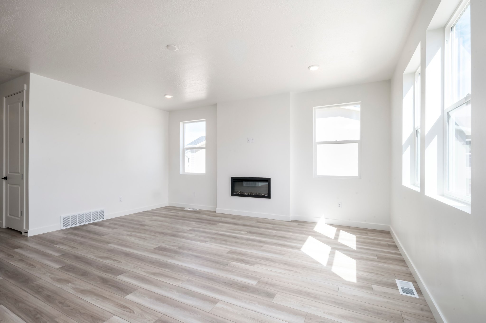 A room with a wood floor and windows.