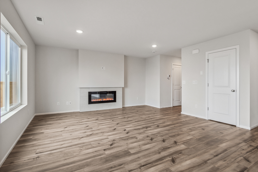 A room with a fireplace and wood floors.