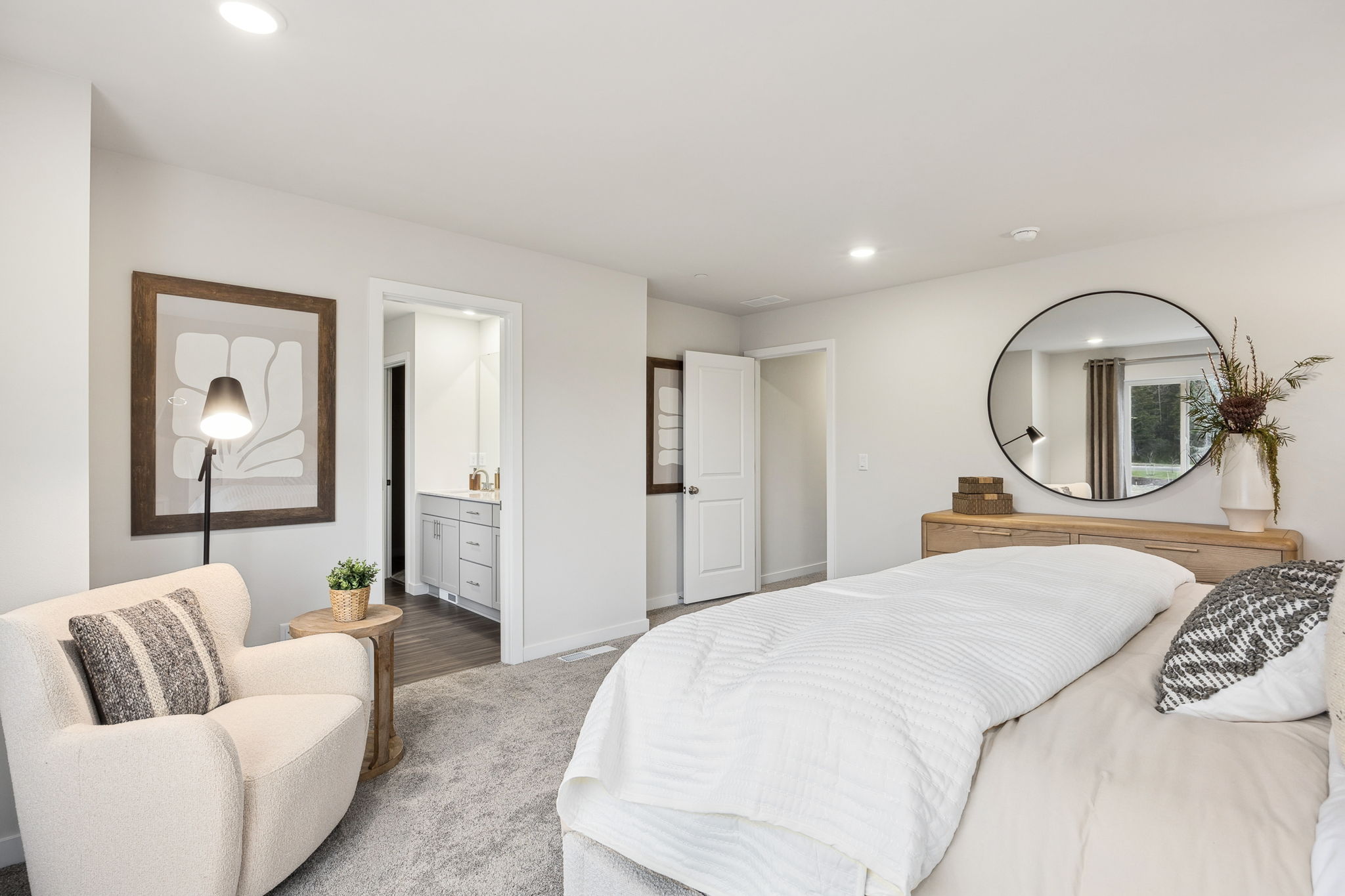 A bedroom with a bed and a mirror.