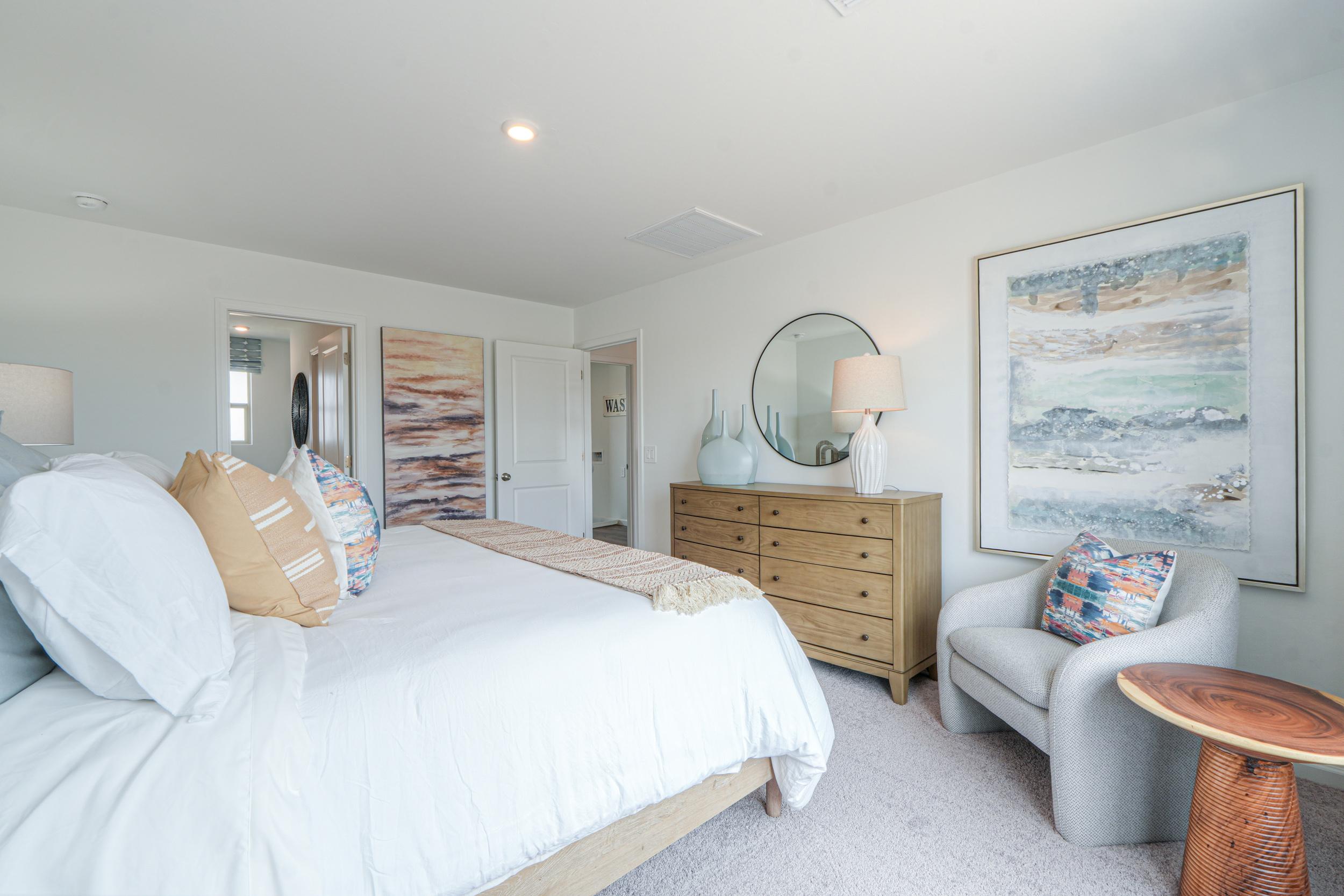 A bedroom with a bed and a chair.