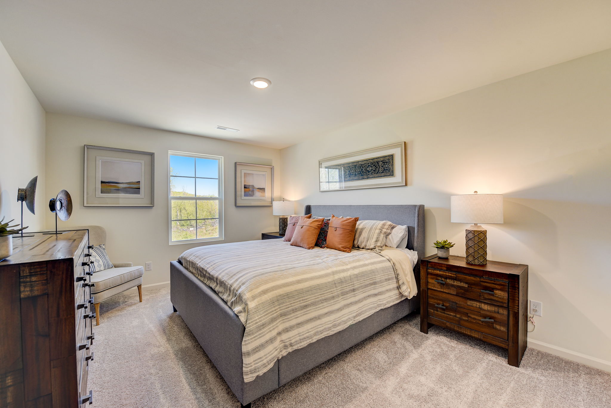 A bedroom with a bed and a chair.