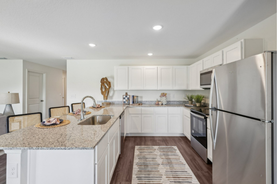 A kitchen with white cabinets.