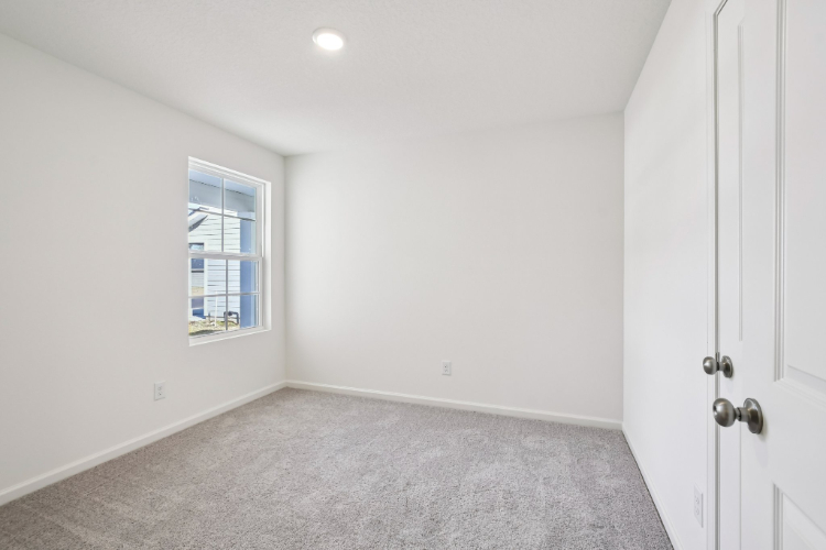 A room with white walls and a window.