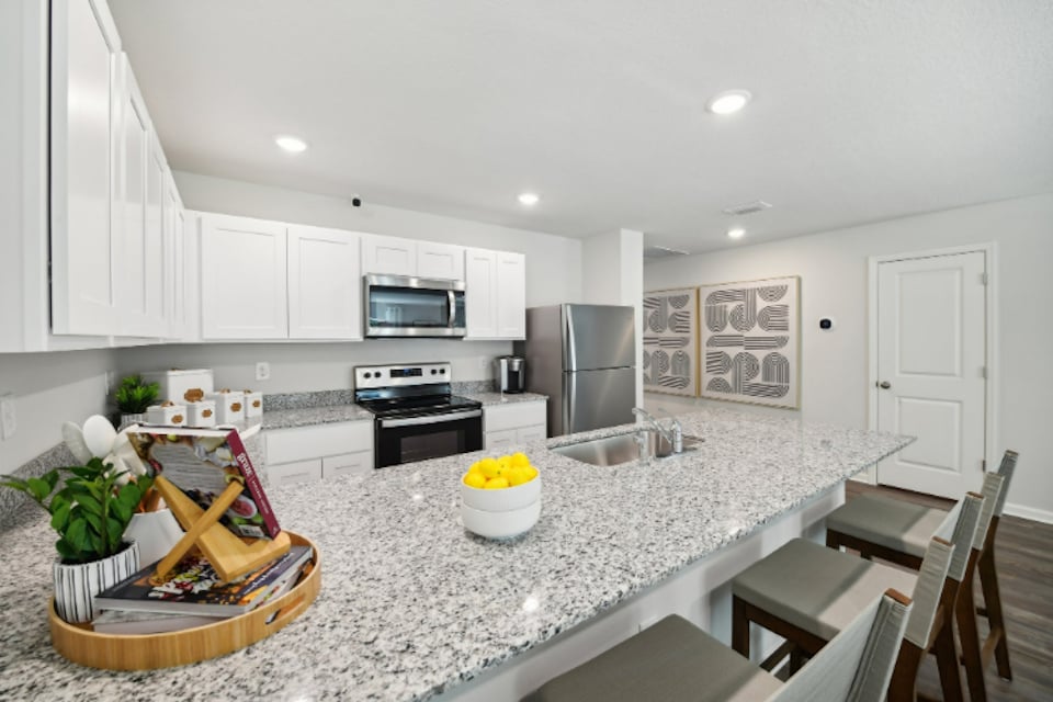 A kitchen with white cabinets.