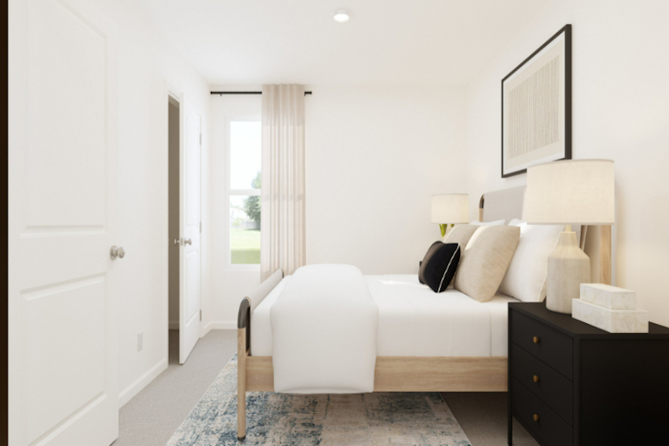 A bedroom with a bed and a lamp.